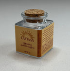 Small glass jar with cork lid on a textured gray surface