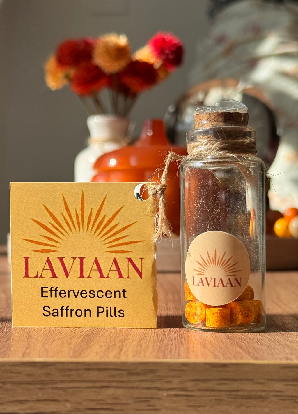 Laviaan effervescent saffron pills in a glass jar on a wooden surface with a decorative background.