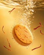 Orange-colored saffron pill fizzing in water