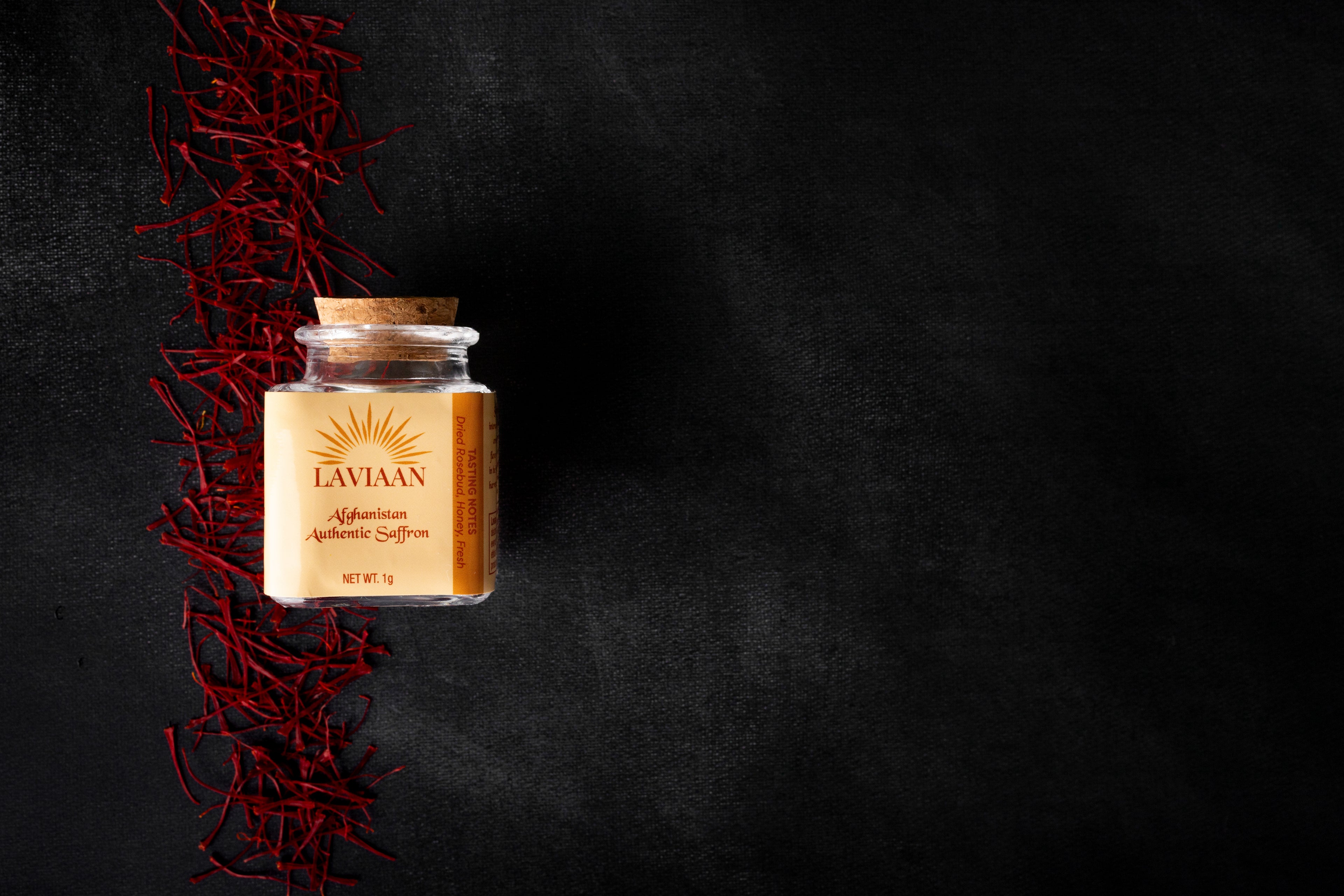 Jar of Lavinaan saffron on a dark background with saffron strands.