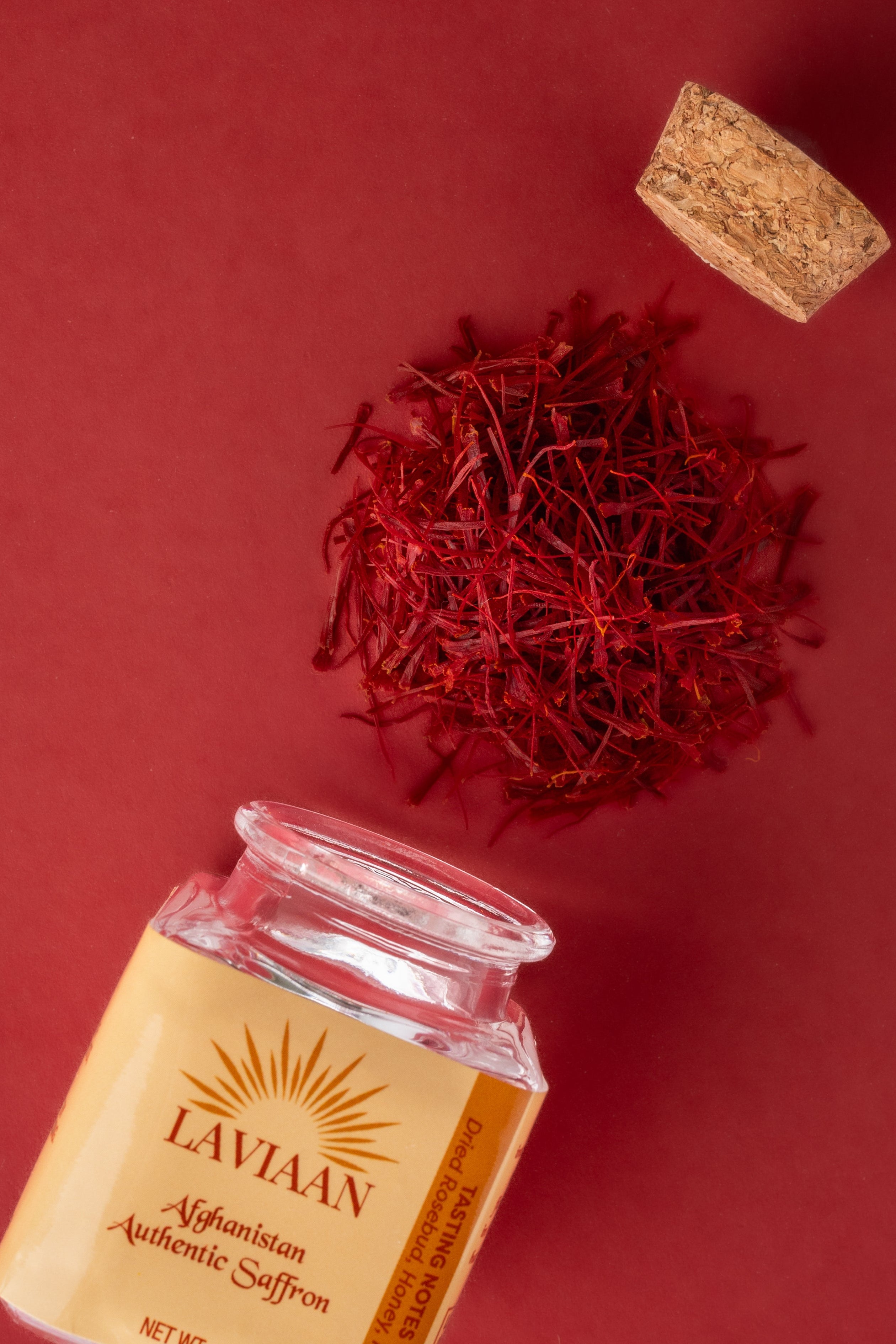 Jar of Lavvaan Ayurvedic Coffee on a red background with a red berry and cork.