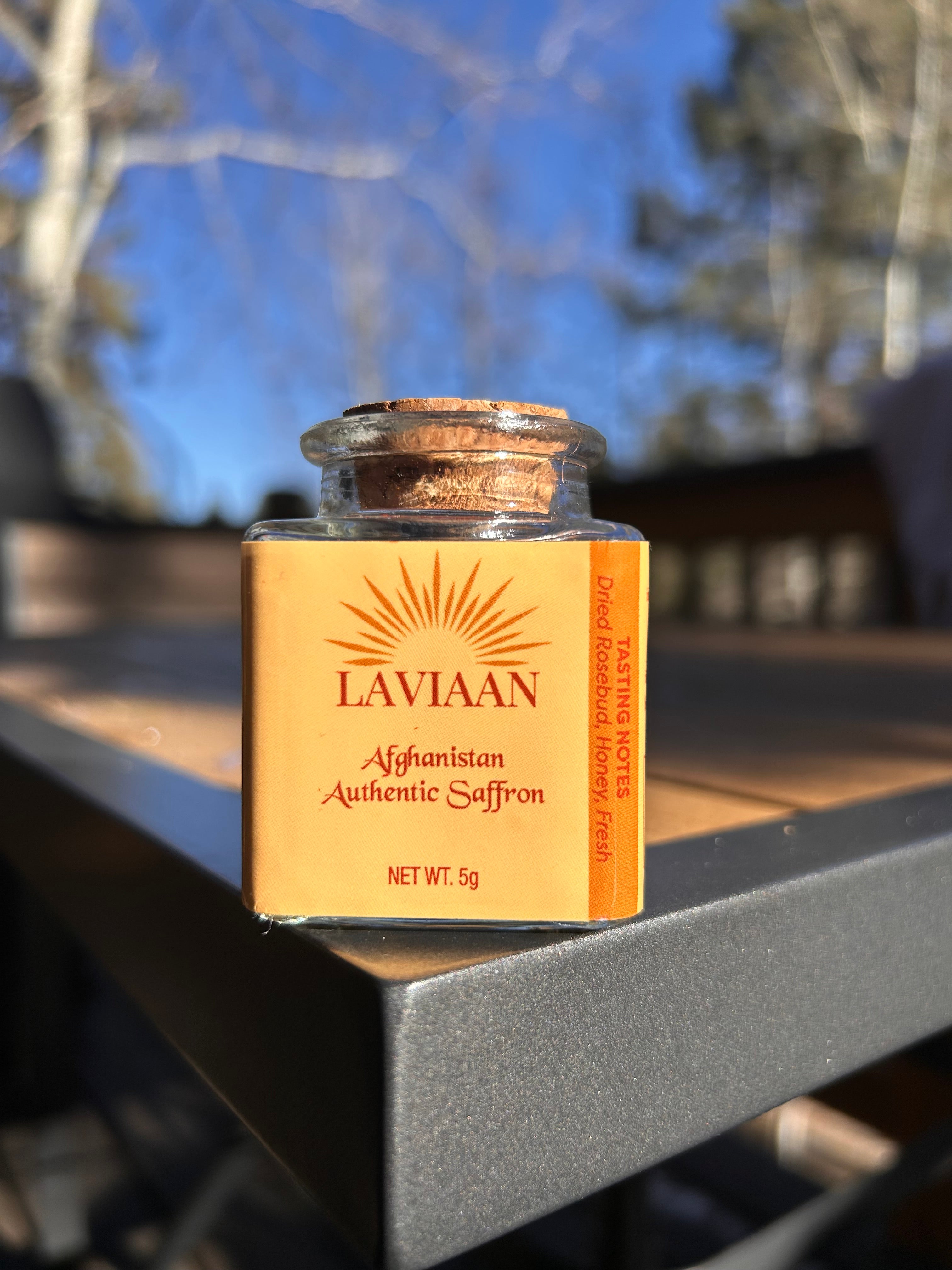 Lavitaan Afghan Saffron packaging with saffron strands on a blurred natural background