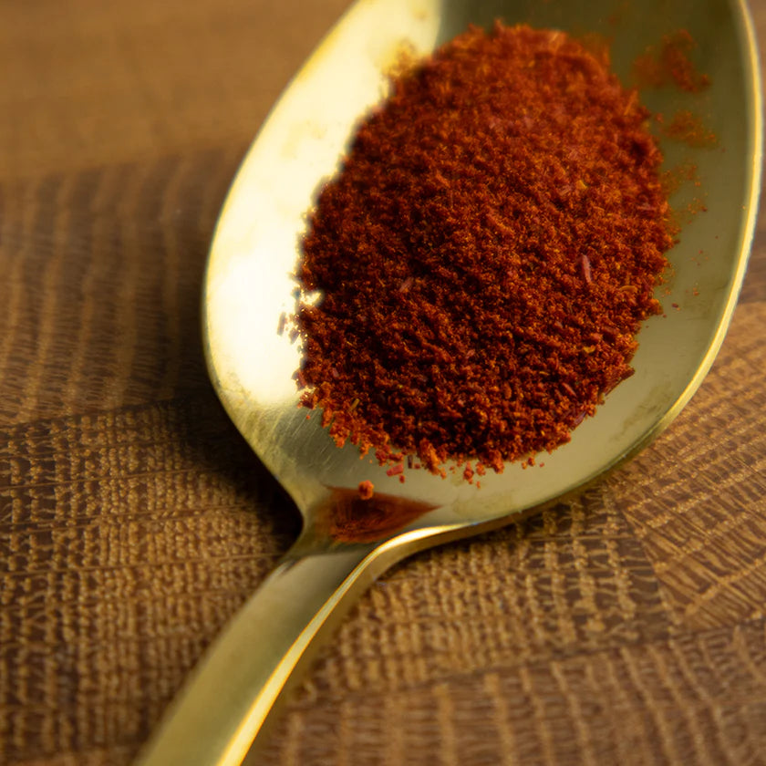 Spoonful of saffron on a textured brown surface
