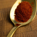Spoonful of saffron on a textured brown surface