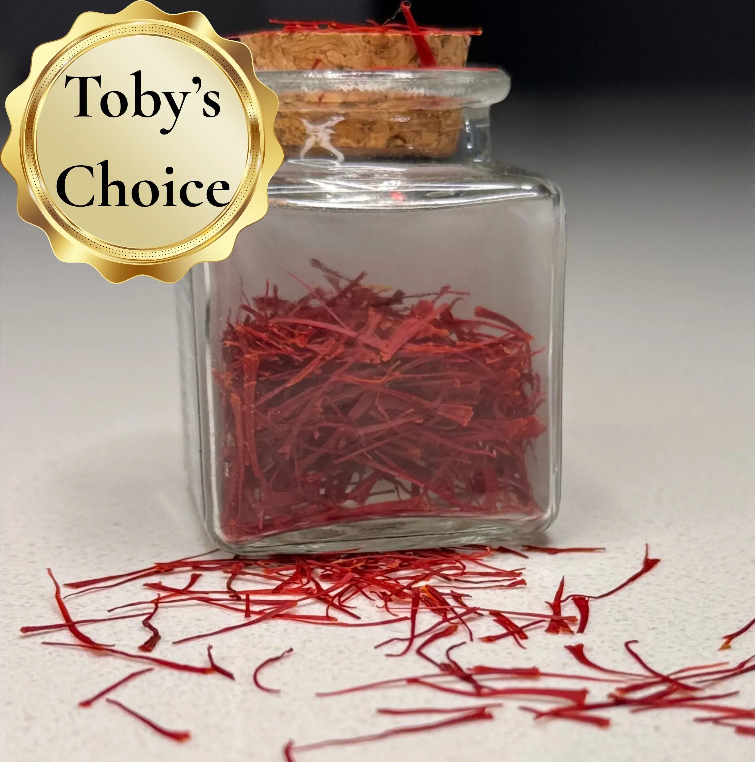 Glass jar with red saffron threads and 'Toby's Choice' label on a light background
